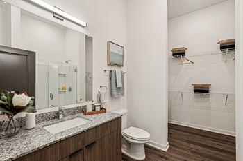 A bathroom with a toilet, sink, and mirror